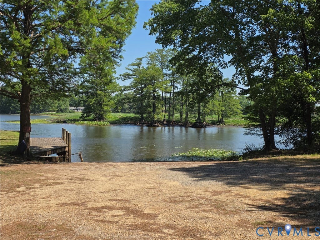 7620 Cypress Drive, Lanexa, VA 23089 Waterfront property featuring a private wooden dock, a boat launch, and mature native trees