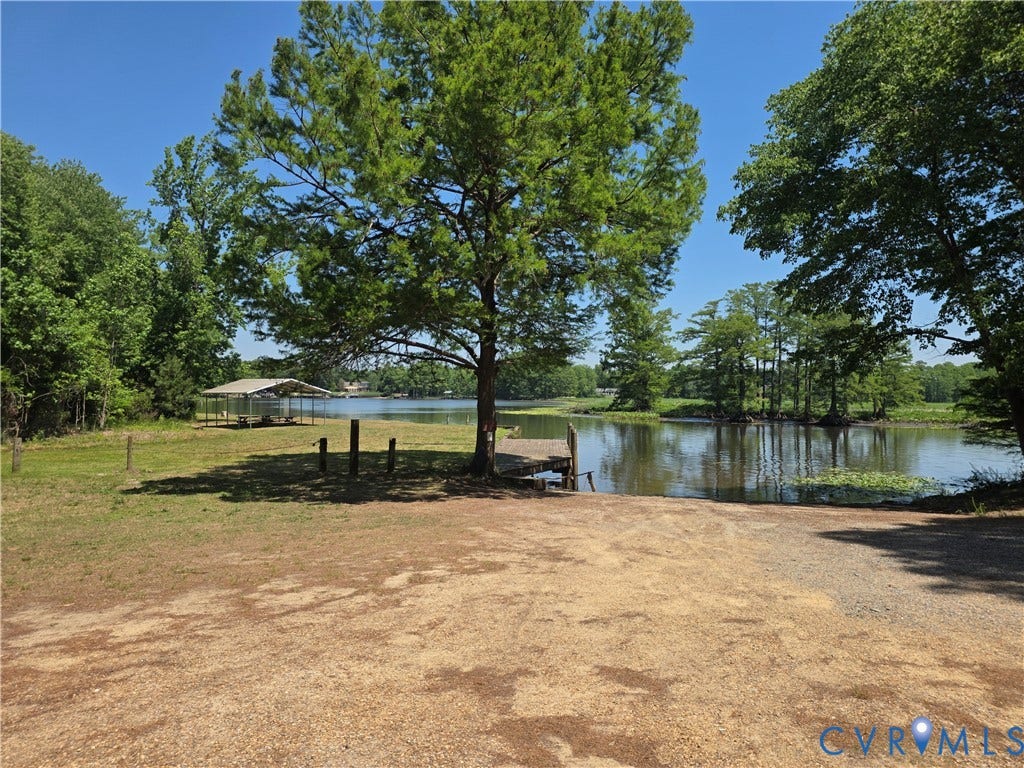 7620 Cypress Drive, Lanexa, VA 23089 Waterfront lot featuring a private pier, mature shade trees, gravel access, and a metal-roofed pavilion