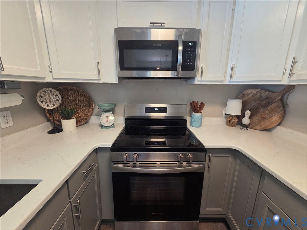 7620 Cypress Drive, Lanexa, VA 23089 Kitchen featuring stainless steel appliances including a range and over-the-range microwave, white countertops, and two-toned cabinetry with satin nickel pulls