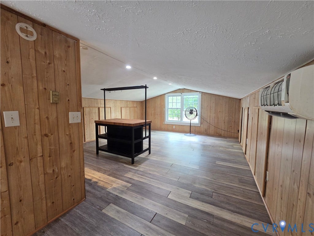 7620 Cypress Drive, Lanexa, VA 23089 Vaulted ceiling featuring recessed lighting, wood-paneled walls, wood-finish flooring, and a wall-mounted ductless air conditioning unit
