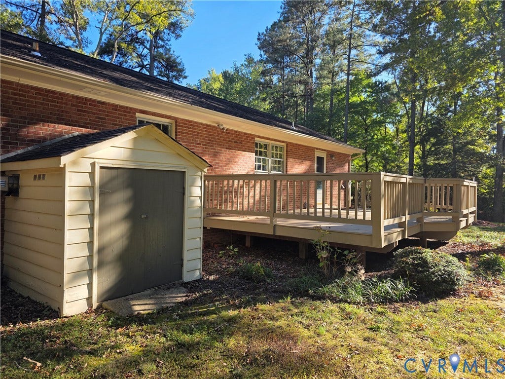 10995 Linderwood Drive, Forest Lake Hills, Mechanicsville, VA 23116 Exterior featuring a brick facade, elevated wooden deck with railings, and an attached storage shed
