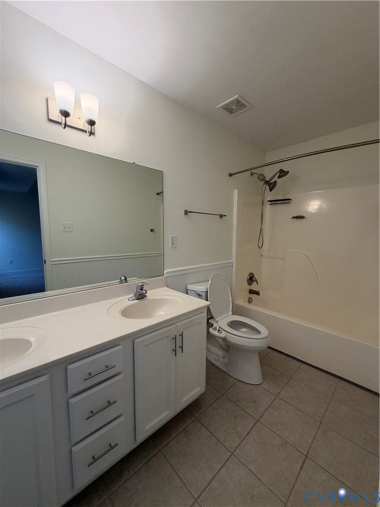3105 Friars Walk Lane, Glen Allen, VA 23059 Double-sink vanity with a solid-surface countertop, tiled flooring, wall-mounted light fixture, and a full-width mirror