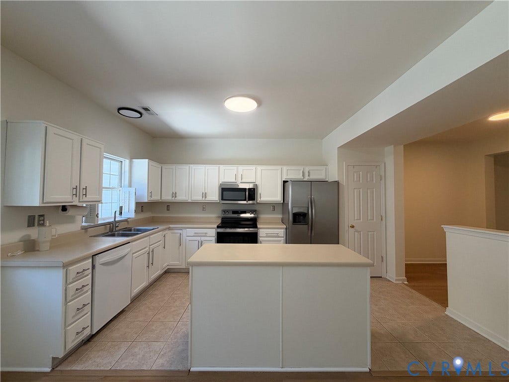 3105 Friars Walk Lane, Glen Allen, VA 23059 Kitchen featuring white cabinetry, center island with stone-finish countertop, dual-basin stainless steel sink, tile flooring, and stainless steel appliances