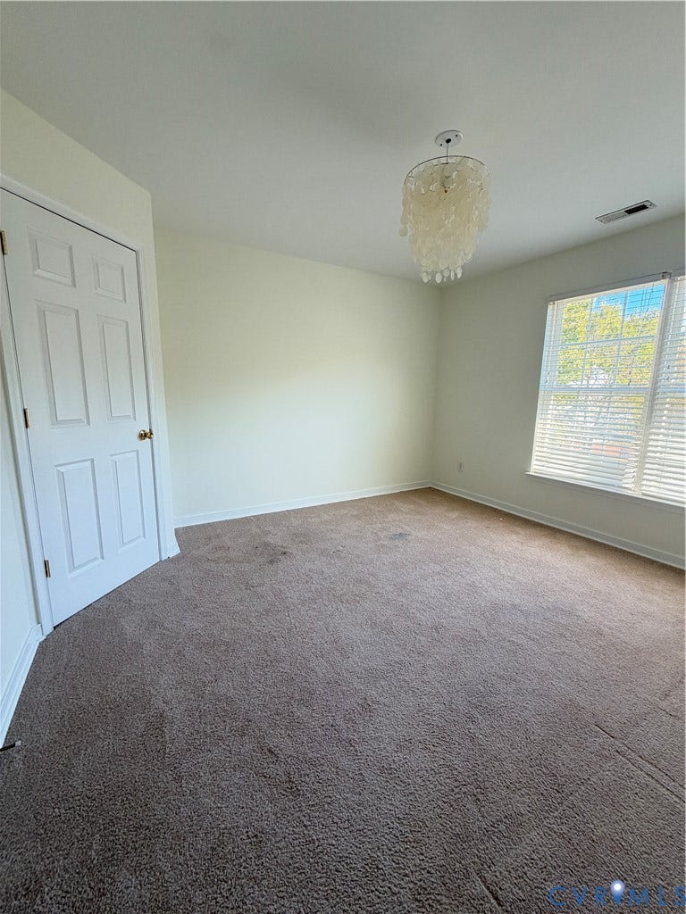 3105 Friars Walk Lane, Glen Allen, VA 23059 Neutral-toned interior space featuring wall-to-wall carpeting, a multi-pane window, and a decorative tiered pendant light fixture