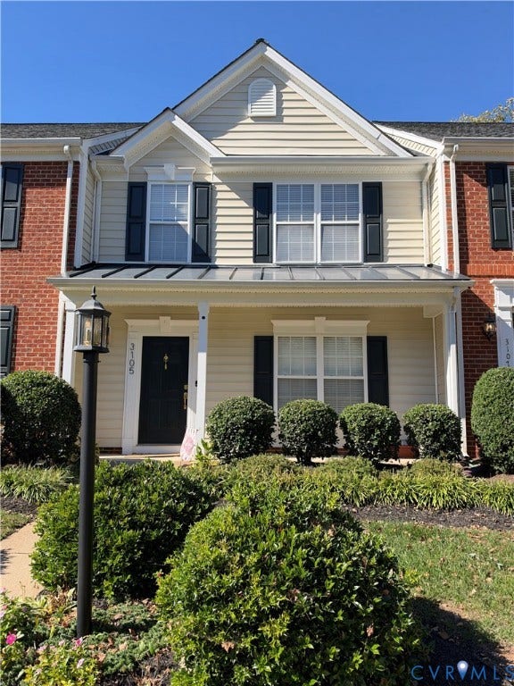 3105 Friars Walk Lane, Glen Allen, VA 23059 Two-story facade featuring brick and horizontal siding, a covered front porch with a metal roof, shuttered windows, and a built-in exterior lamp post