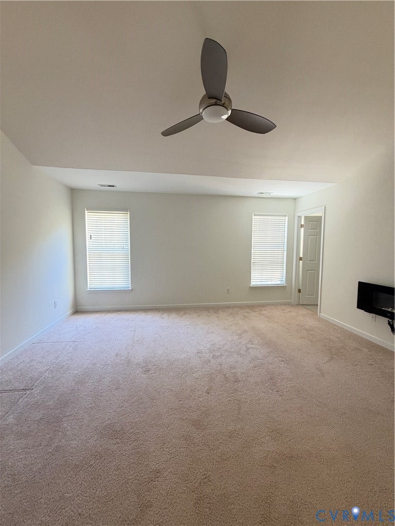 3105 Friars Walk Lane, Glen Allen, VA 23059 Vaulted ceiling featuring a three-blade modern ceiling fan, wall-mounted electric fireplace, and dual windows with integrated blinds