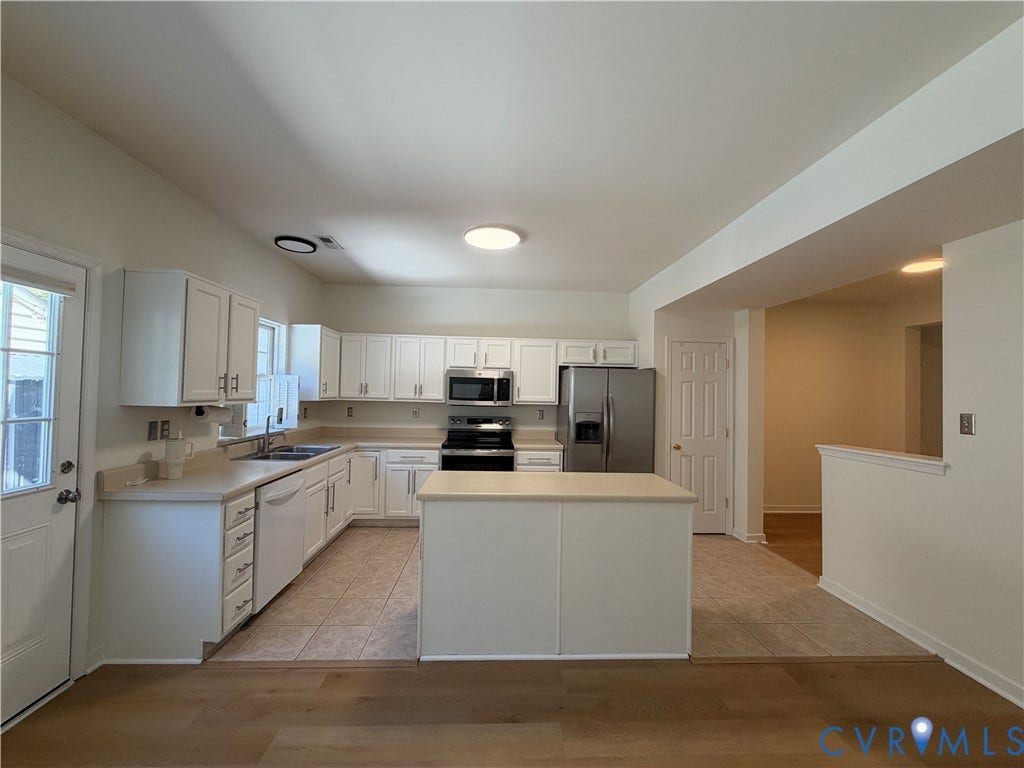 3105 Friars Walk Lane, Glen Allen, VA 23059 Kitchen featuring white cabinetry, center island, solid surface countertops, stainless steel appliances, and tile flooring