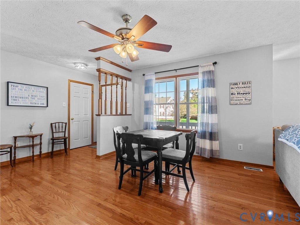 209 Taraby Drive, Hunters Run, Sandston, VA 23150 Wood-finish flooring, half-wall with wooden balustrade, multi-blade ceiling fan with integrated lighting, and multi-pane window