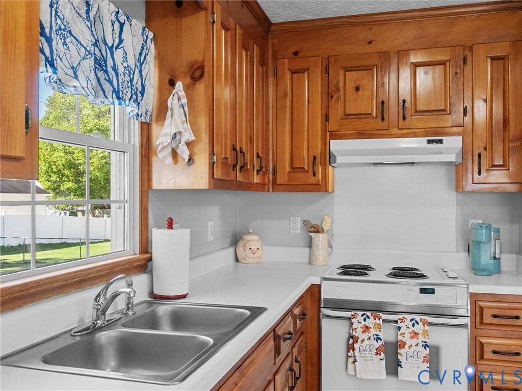 209 Taraby Drive, Hunters Run, Sandston, VA 23150 Kitchen featuring solid wood cabinetry, a dual-basin stainless steel sink with a chrome faucet, and an integrated range hood over the cooktop