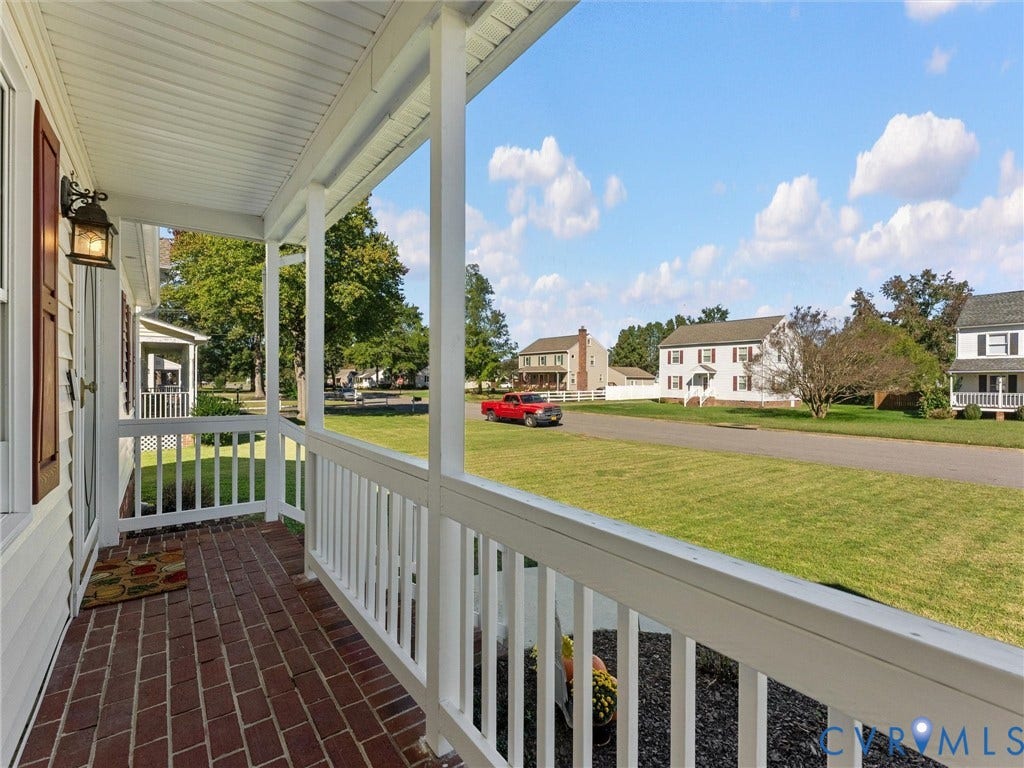 209 Taraby Drive, Hunters Run, Sandston, VA 23150 Covered front porch featuring brick flooring, white railings, and an exterior wall-mounted light fixture