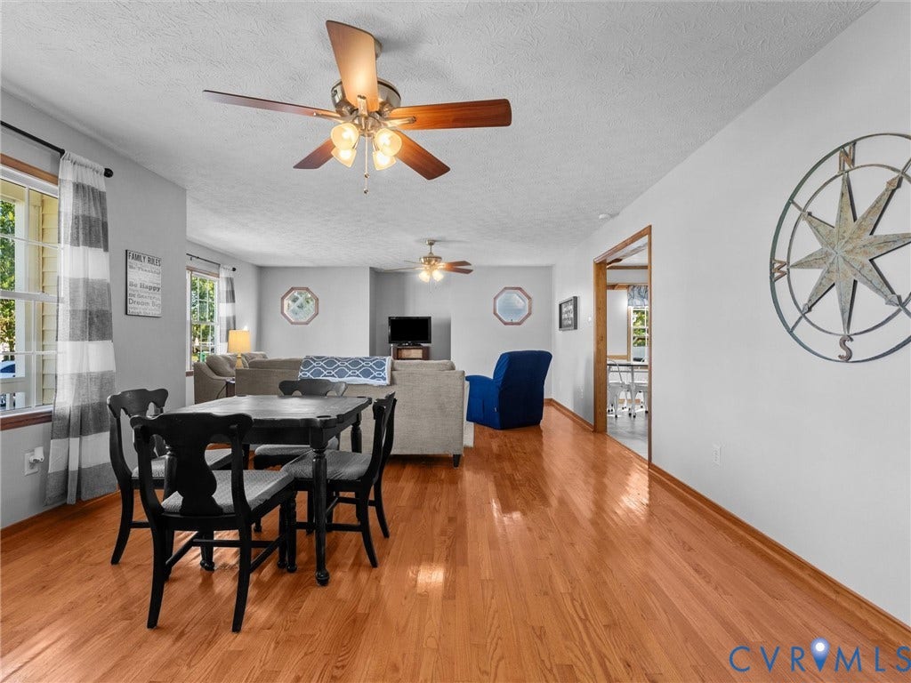 209 Taraby Drive, Hunters Run, Sandston, VA 23150 Open-concept living space featuring wood-finish flooring, dual ceiling fans with integrated lighting, and multiple windows