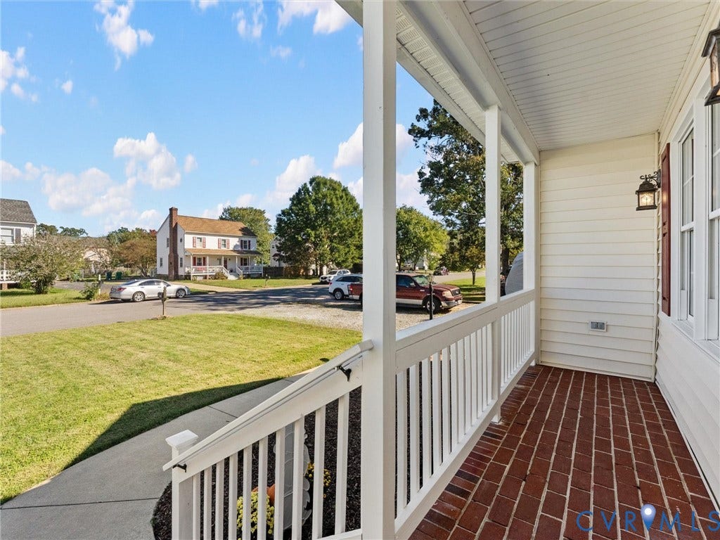 209 Taraby Drive, Hunters Run, Sandston, VA 23150 Covered front porch featuring a red brick floor, white picket-style railing, and wall-mounted exterior lighting