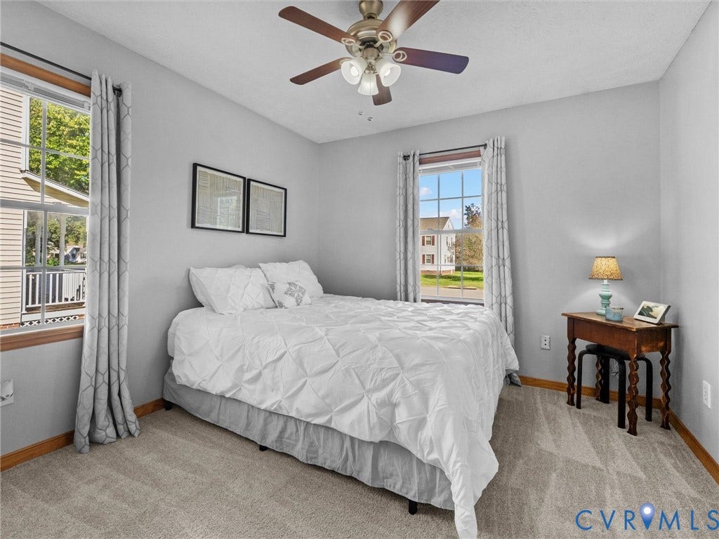 209 Taraby Drive, Hunters Run, Sandston, VA 23150 Neutral-toned interior featuring wall-to-wall carpeting, multiple double-hung windows with exterior muntins, and a ceiling-mounted light fixture with a fan