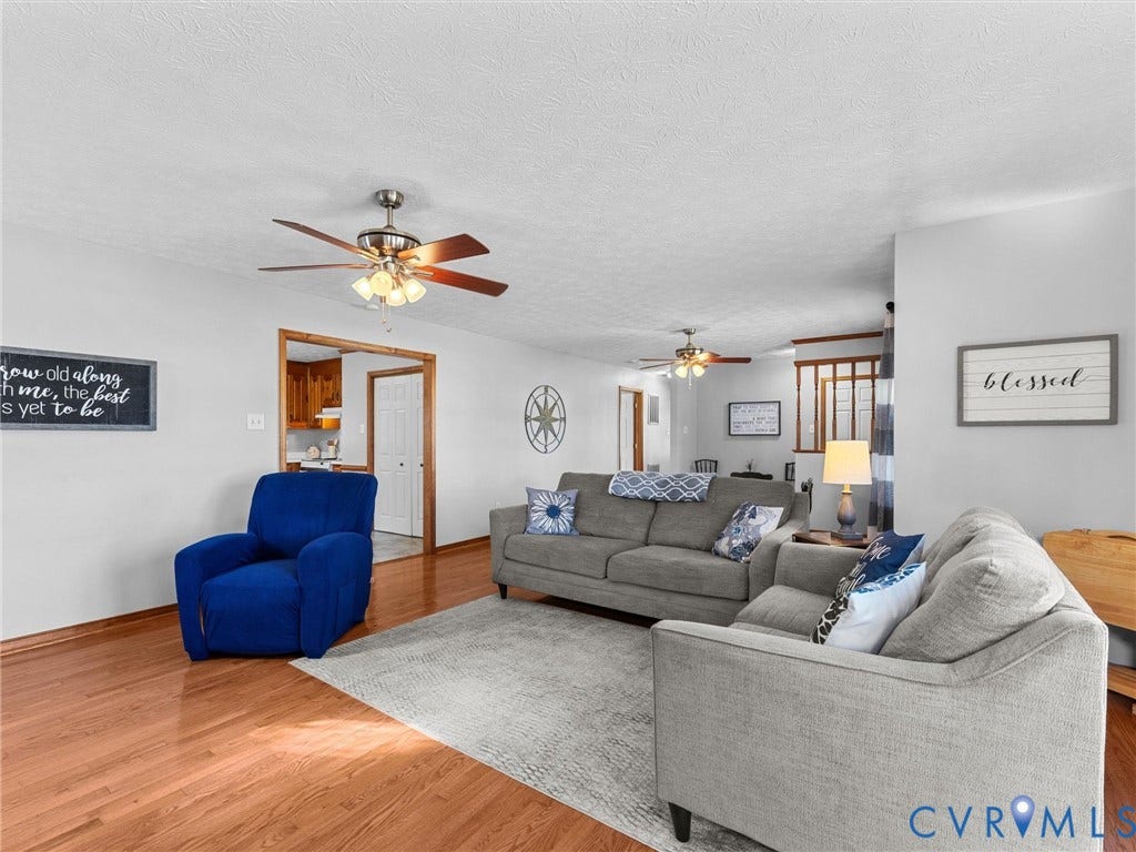 209 Taraby Drive, Hunters Run, Sandston, VA 23150 Spacious interior featuring wood-finish flooring, two ceiling fans with multi-light fixtures, and wood-toned door trim
