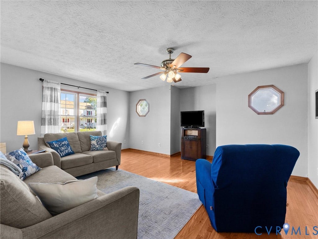 209 Taraby Drive, Hunters Run, Sandston, VA 23150 Living area featuring wood-finish flooring, a ceiling fan with integrated light fixture, double-pane window, and decorative octagonal accent windows