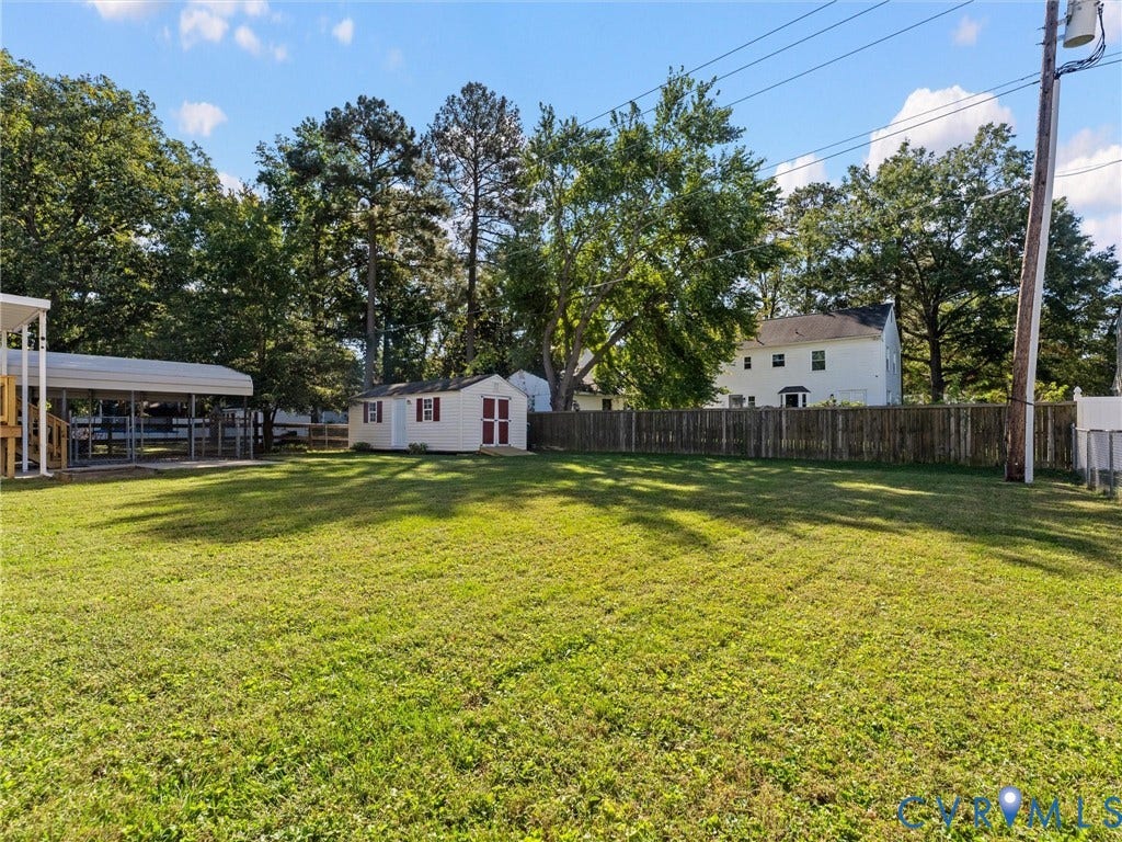 209 Taraby Drive, Hunters Run, Sandston, VA 23150 Expansive backyard featuring a level lawn, mature trees, a detached storage shed, and perimeter wood fencing
