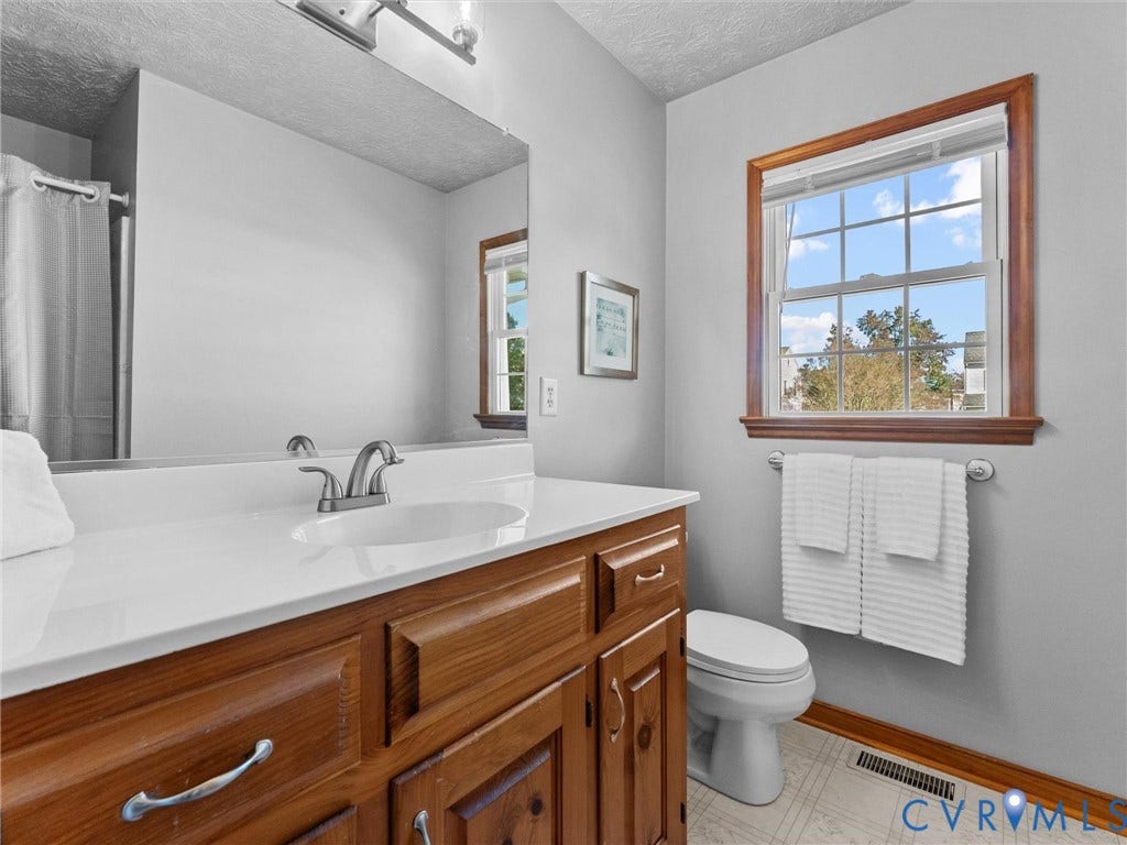 209 Taraby Drive, Hunters Run, Sandston, VA 23150 Bathroom featuring a wood vanity with a white countertop, an integrated sink with a brushed-nickel faucet, a large wall-mounted mirror, and a single-hung window with wood trim