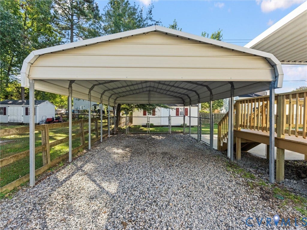 209 Taraby Drive, Hunters Run, Sandston, VA 23150 Detached metal carport featuring a gabled roof, gravel foundation, and timber perimeter fencing