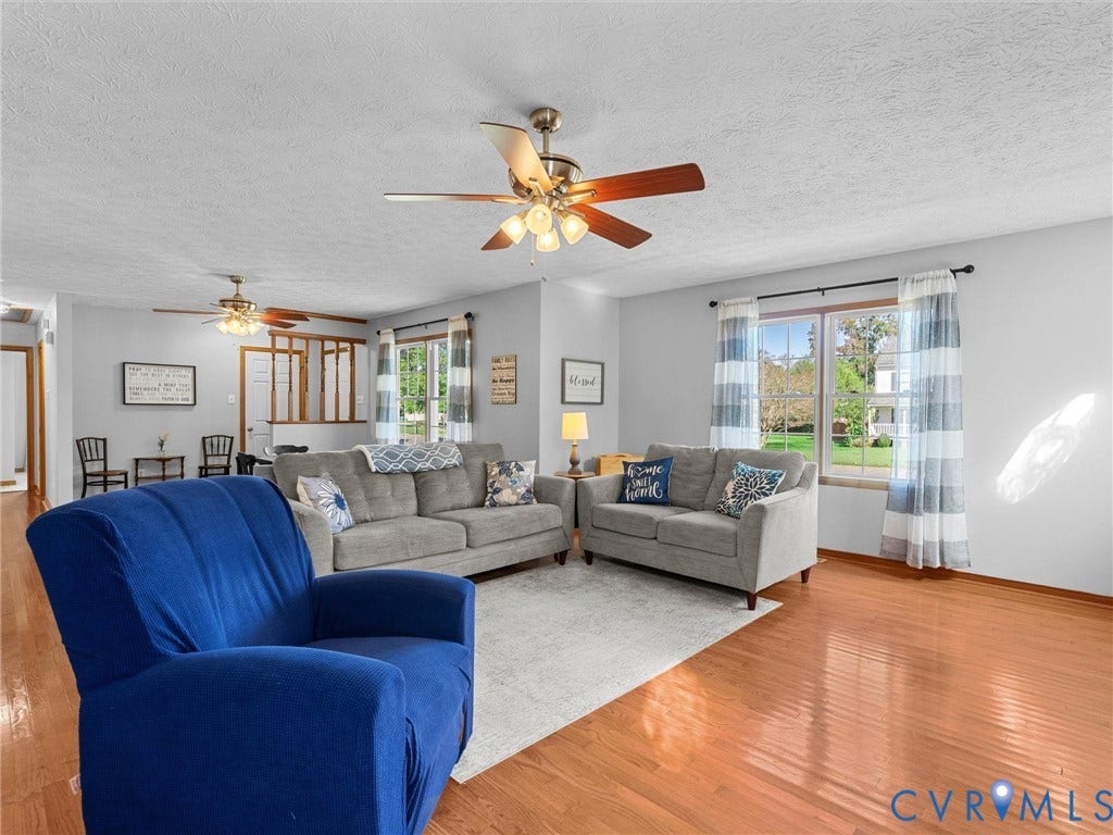 209 Taraby Drive, Hunters Run, Sandston, VA 23150 Living space featuring wood-finish flooring, dual ceiling fans with integrated lighting, and multiple windows