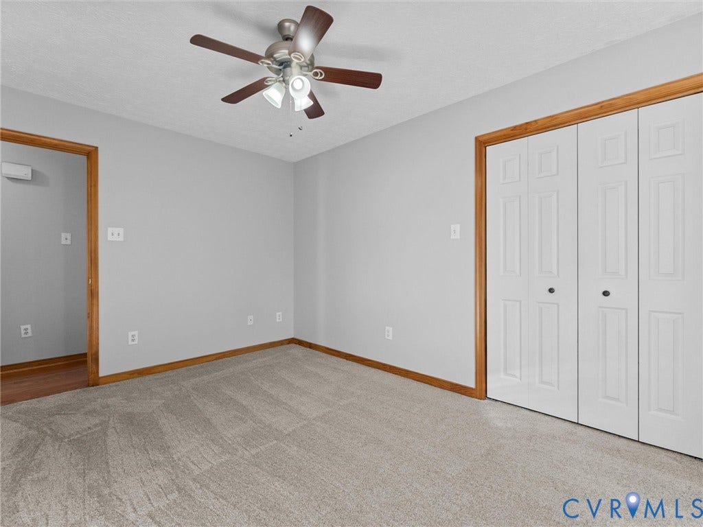 209 Taraby Drive, Hunters Run, Sandston, VA 23150 Room interior featuring neutral wall paint, carpeted flooring, a ceiling fan with integrated lighting, and white bifold closet doors with wood trim finish