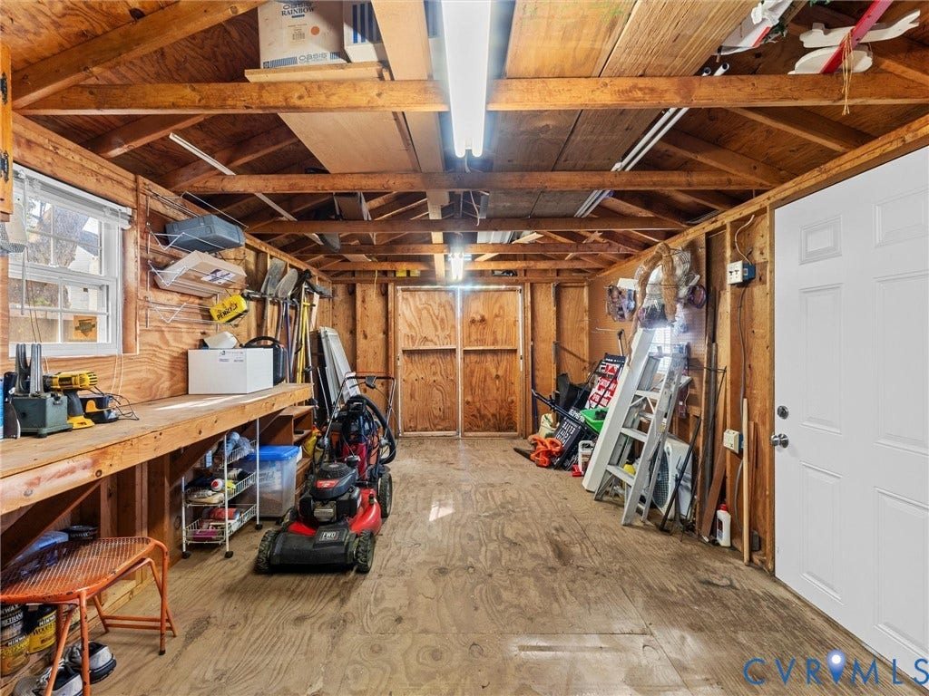 209 Taraby Drive, Hunters Run, Sandston, VA 23150 Outbuilding featuring wood-paneled walls, exposed rafter ceiling, built-in workbench, double-door entry, and linear fluorescent lighting