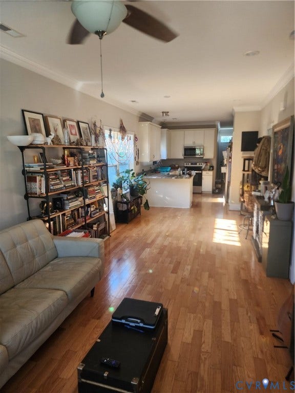 1502 N 19th Street, Church Hill, Richmond, VA 23223 Open-concept space featuring wood-finish flooring, recessed lighting, crown molding, and kitchen cabinetry with integrated microwave and oven