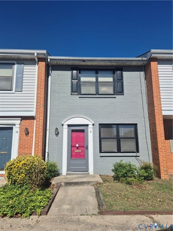 17 Jarratt Court, Petersburg, VA 23803 Painted brick facade featuring a decorative arched doorway pediment, shuttered windows, and a concrete walkway