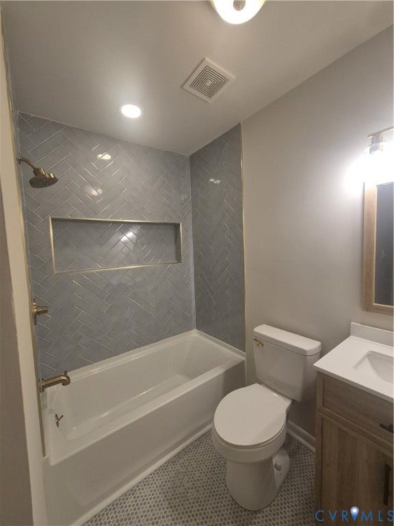 17 Jarratt Court, Petersburg, VA 23803 Full bathroom featuring herringbone-patterned wall tile, recessed shower niche, wood-finish vanity with white countertop, and hexagonal floor tiling