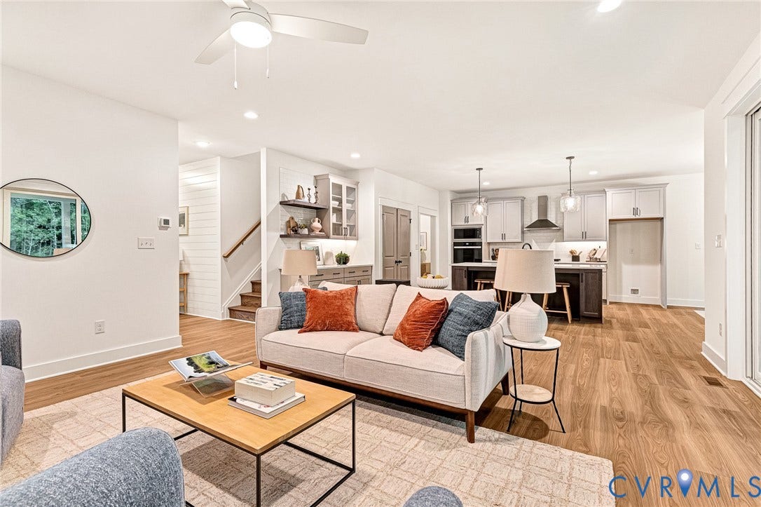 9107 Terroir Lane, Viniterra Villas, New Kent, VA 23124 Open concept living area featuring wood-finish flooring, recessed lighting, a modern ceiling fan, built-in cabinetry with open shelving, and a kitchen island with pendant lighting