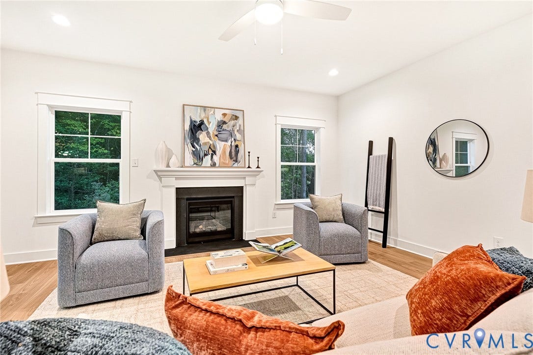 9107 Terroir Lane, Viniterra Villas, New Kent, VA 23124 Living area featuring a fireplace with a white mantel, wood-finish flooring, and white-framed windows