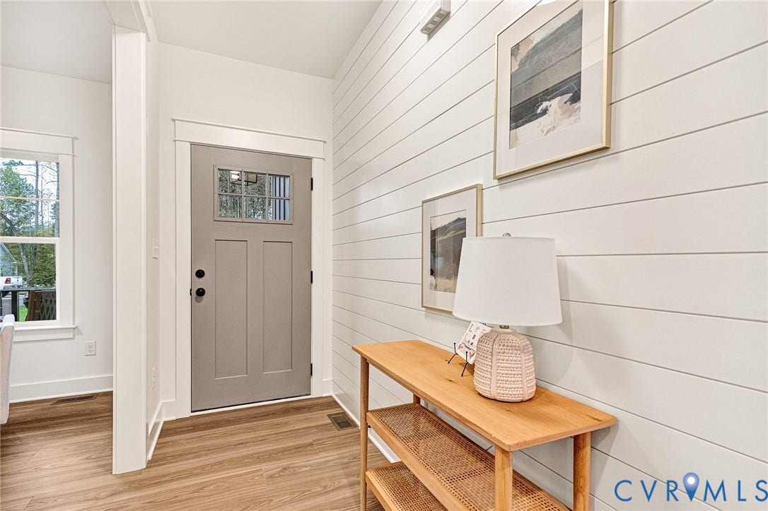 9107 Terroir Lane, Viniterra Villas, New Kent, VA 23124 Entryway featuring white horizontal shiplap wall paneling, wood-finish flooring, and a grey Craftsman-style front door with a single-pane glass insert