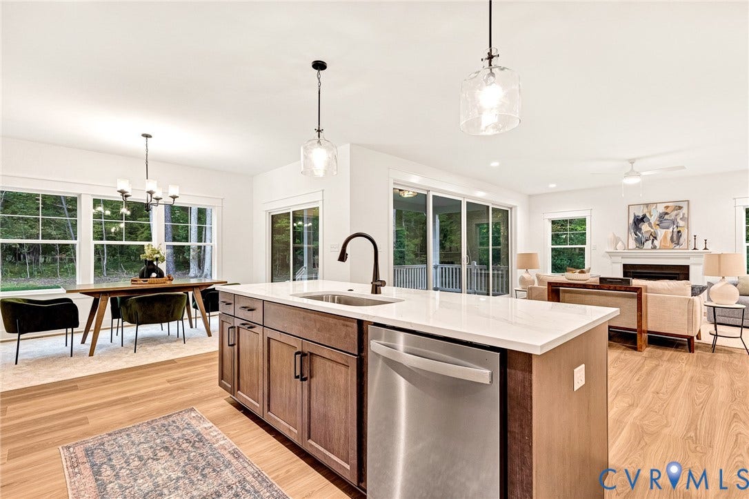 9107 Terroir Lane, Viniterra Villas, New Kent, VA 23124 Kitchen island with stone-finish countertop, undermount sink, matte black faucet, and built-in stainless steel dishwasher, complemented by wood-finish flooring and pendant lighting