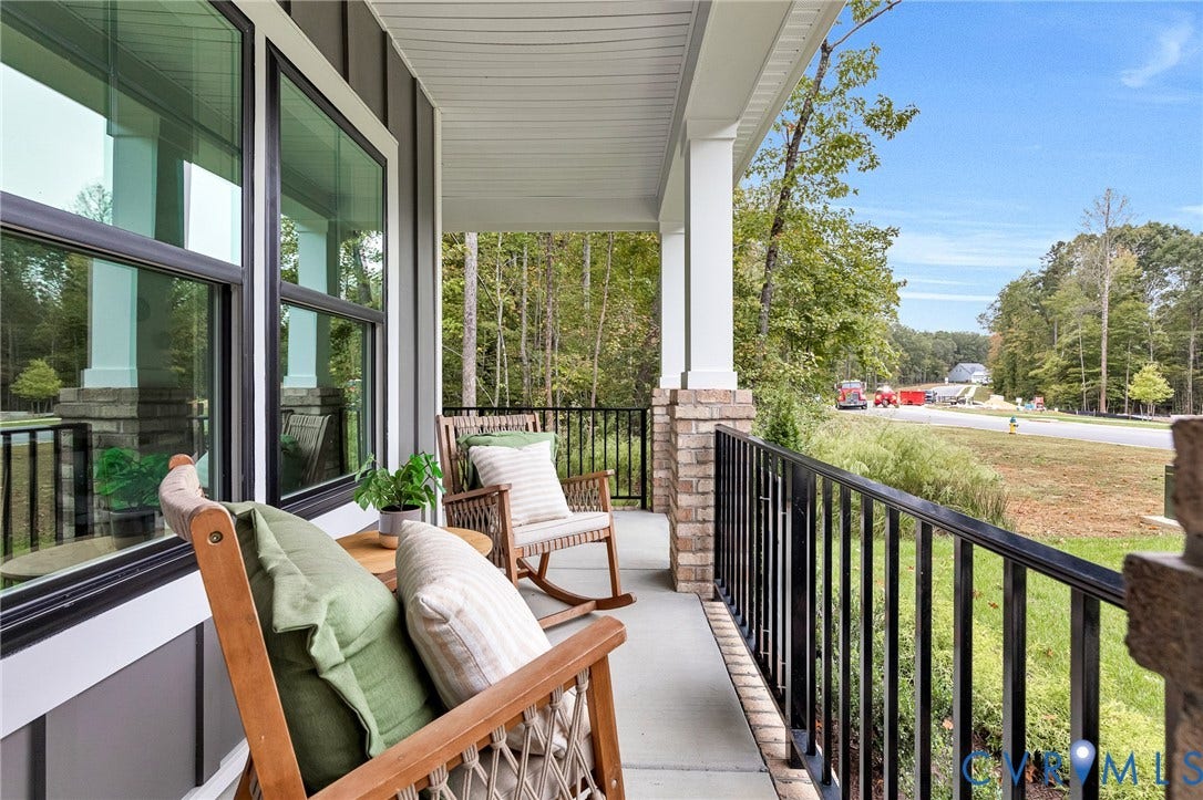 9107 Terroir Lane, Viniterra Villas, New Kent, VA 23124 Covered porch featuring concrete flooring, black metal railing, and columns with brick masonry bases