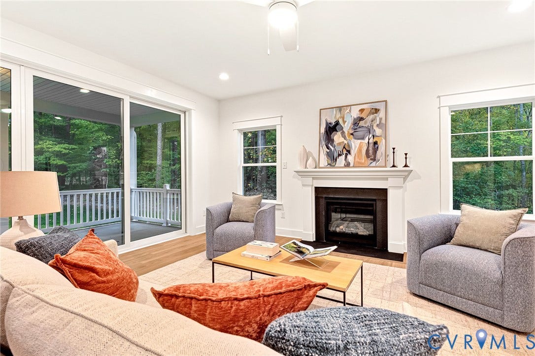 9107 Terroir Lane, Viniterra Villas, New Kent, VA 23124 Living area featuring wood-finish flooring, a fireplace with an ornate mantel, sliding glass doors, and large windows with grid muntins