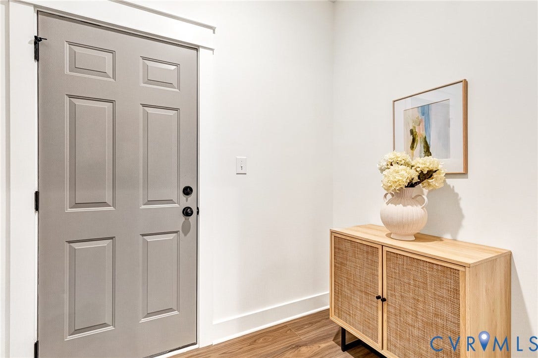9107 Terroir Lane, Viniterra Villas, New Kent, VA 23124 Six-panel door with matte black hardware, crisp white door casing, and wood-finish flooring