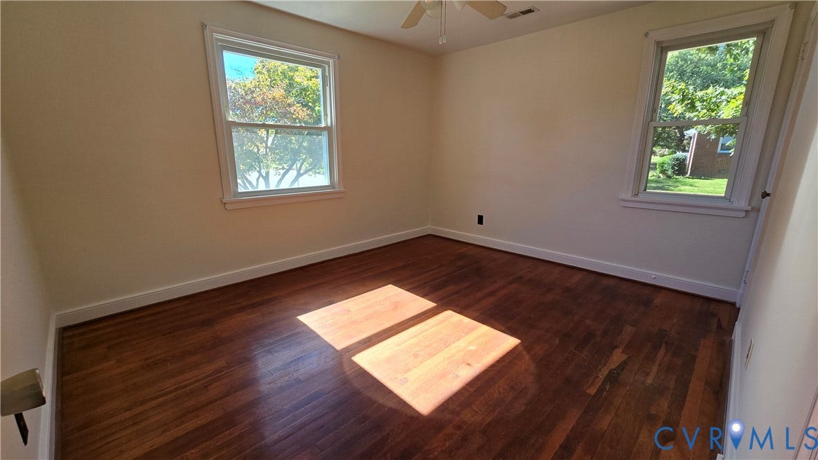 38 Eastlake Drive, Sandston, Sandston, VA 23150 Room featuring wood-finish flooring, two windows with white trim, and a ceiling-mounted fan