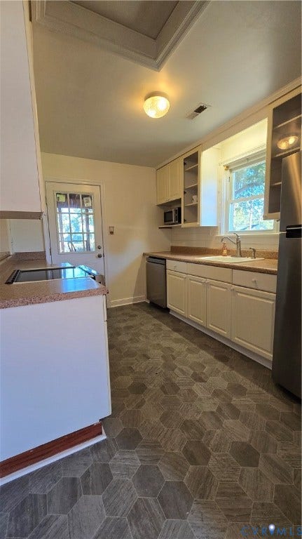 38 Eastlake Drive, Sandston, Sandston, VA 23150 Kitchen featuring white shaker-style cabinetry, stainless steel appliances, hexagonal patterned flooring, integrated countertop, and a window above the basin