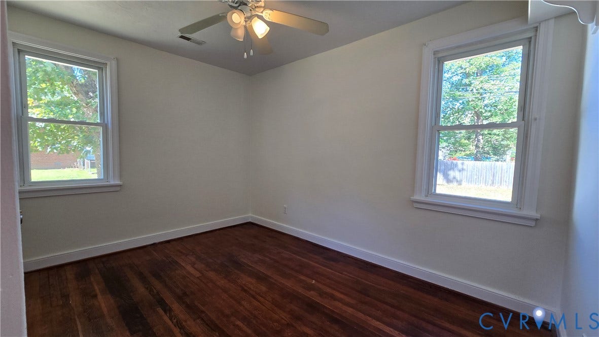 38 Eastlake Drive, Sandston, Sandston, VA 23150 Interior space featuring wood-finish flooring, two double-hung windows, and a ceiling-mounted light fixture with a central fan
