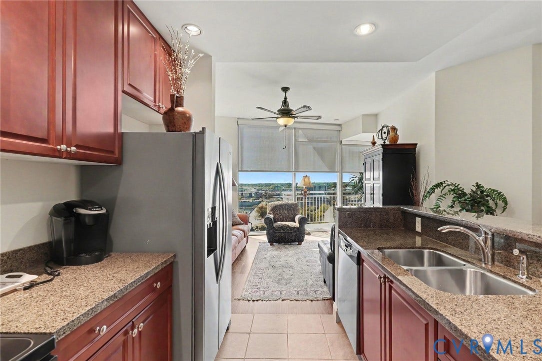 301 Virginia Street, #U1712, Richmond, VA 23219 Kitchen featuring dark wood-finish cabinetry, stone-finish countertops, stainless steel appliances, a dual-basin undermount sink, and recessed lighting
