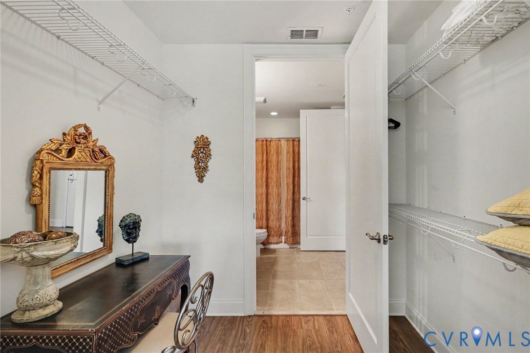 301 Virginia Street, #U1712, Richmond, VA 23219 Walk-in closet featuring dual-tier wire shelving, wood-finish flooring, and a solid-core interior door