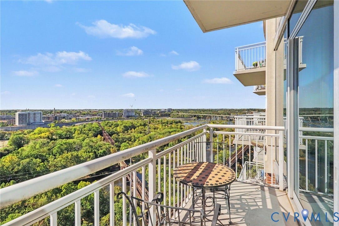 301 Virginia Street, #U1712, Richmond, VA 23219 Private balcony featuring a metal railing and floor-to-ceiling glass sliding doors, overlooking an expansive natural landscape and urban skyline