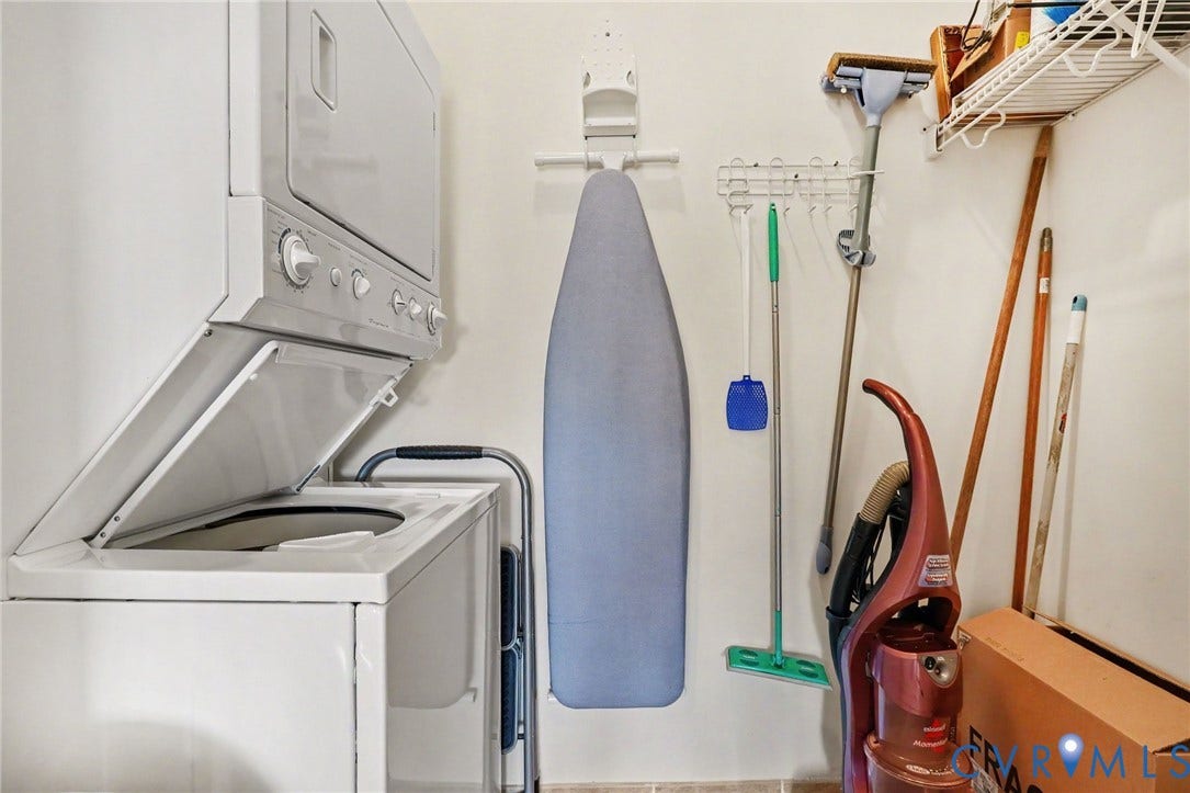 301 Virginia Street, #U1712, Richmond, VA 23219 Dedicated laundry area featuring a white stacked washer and dryer unit and built-in wire wall shelving