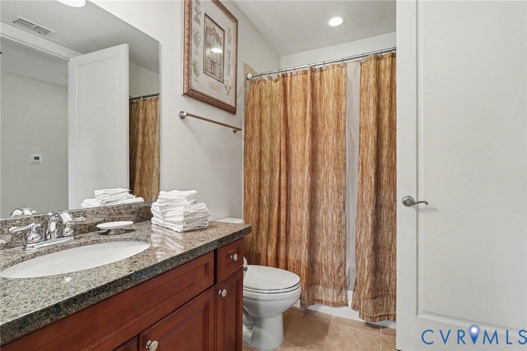 301 Virginia Street, #U1712, Richmond, VA 23219 Bathroom featuring a vanity with stone-finish countertop, undermount sink, chrome faucet, wood-finish cabinetry, and recessed lighting