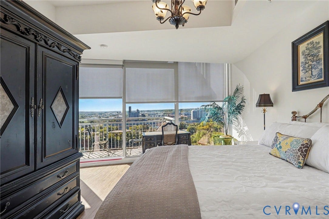 301 Virginia Street, #U1712, Richmond, VA 23219 Floor-to-ceiling windows, wood-finish flooring, recessed lighting, ornate metal chandelier, and attached balcony