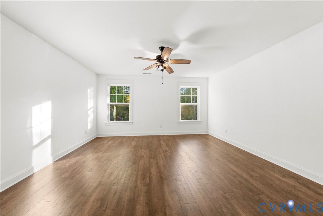 2613 Lilybank Place, NewMarket At RounTrey, Midlothian, VA 23112 Interior space featuring wood-finish flooring, white walls, dual windows, and a ceiling fan with light fixture