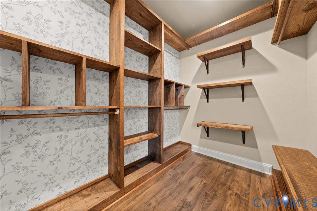 2613 Lilybank Place, NewMarket At RounTrey, Midlothian, VA 23112 Custom storage space featuring built-in wood shelving, patterned wallpaper accents, wood-finish flooring, and wall-mounted wooden shelves with metal brackets
