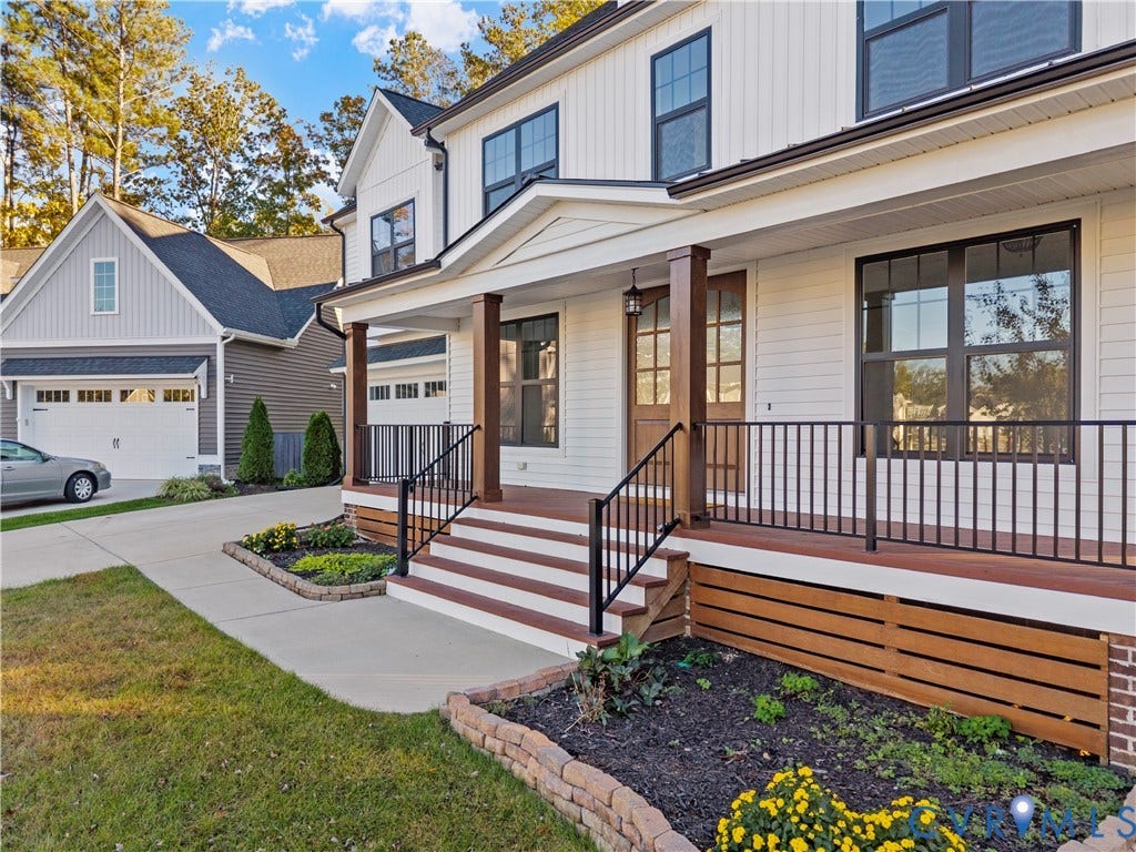 2613 Lilybank Place, NewMarket At RounTrey, Midlothian, VA 23112 Modern farmhouse exterior featuring horizontal siding, a covered porch with wood-finish decking, dark metal railings, and decorative wood-slat skirting