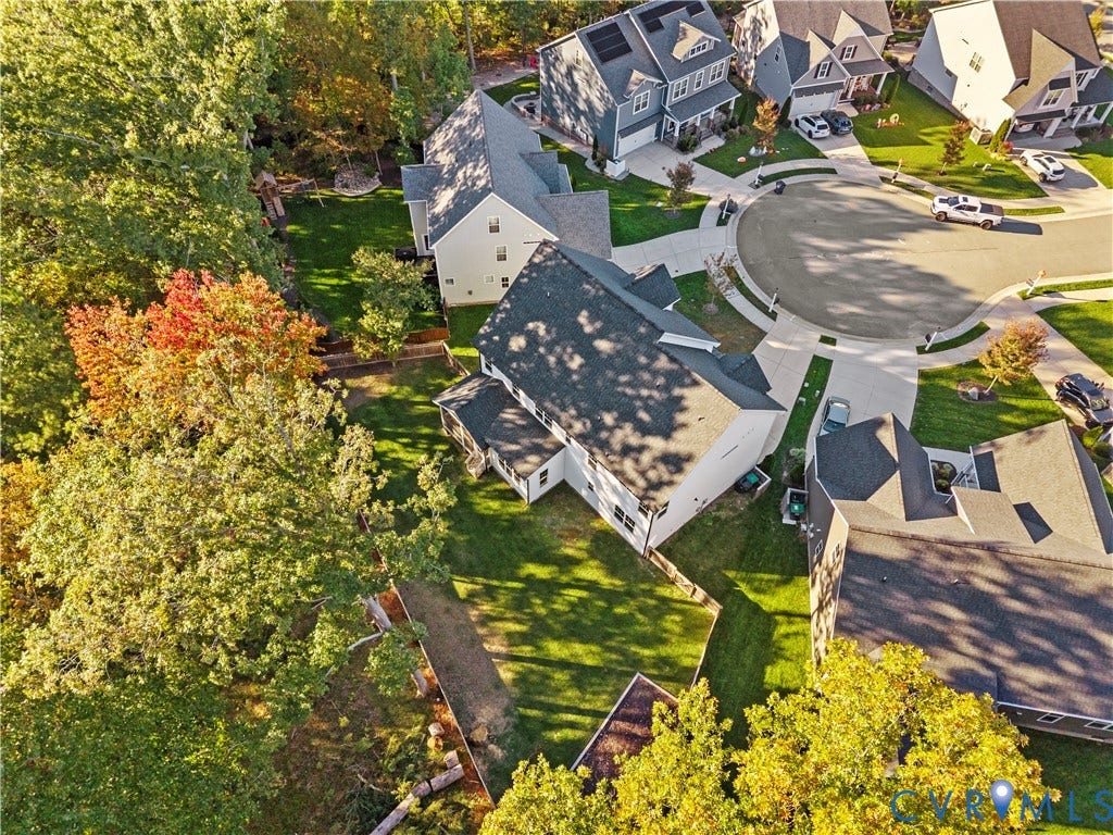 2613 Lilybank Place, NewMarket At RounTrey, Midlothian, VA 23112 Aerial perspective of a multi-level suburban residence featuring an asphalt shingle roof, concrete driveway, and expansive grass-covered backyard enclosed by privacy fencing