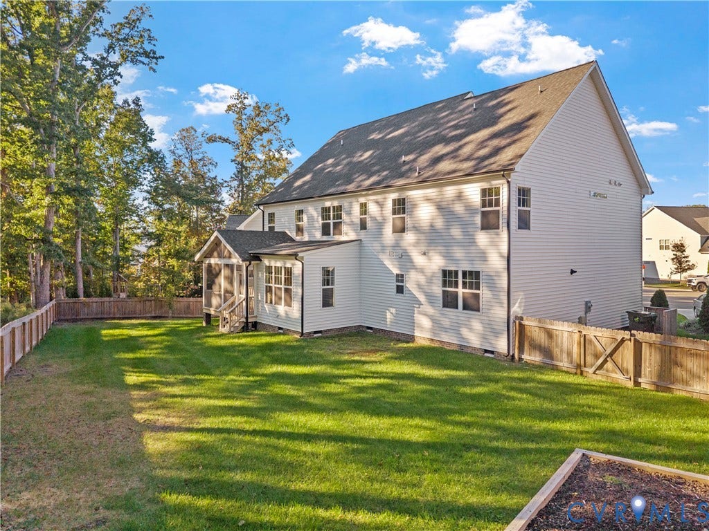 2613 Lilybank Place, NewMarket At RounTrey, Midlothian, VA 23112 Rear exterior featuring vinyl siding, screened-in porch, fully fenced backyard, and raised garden bed