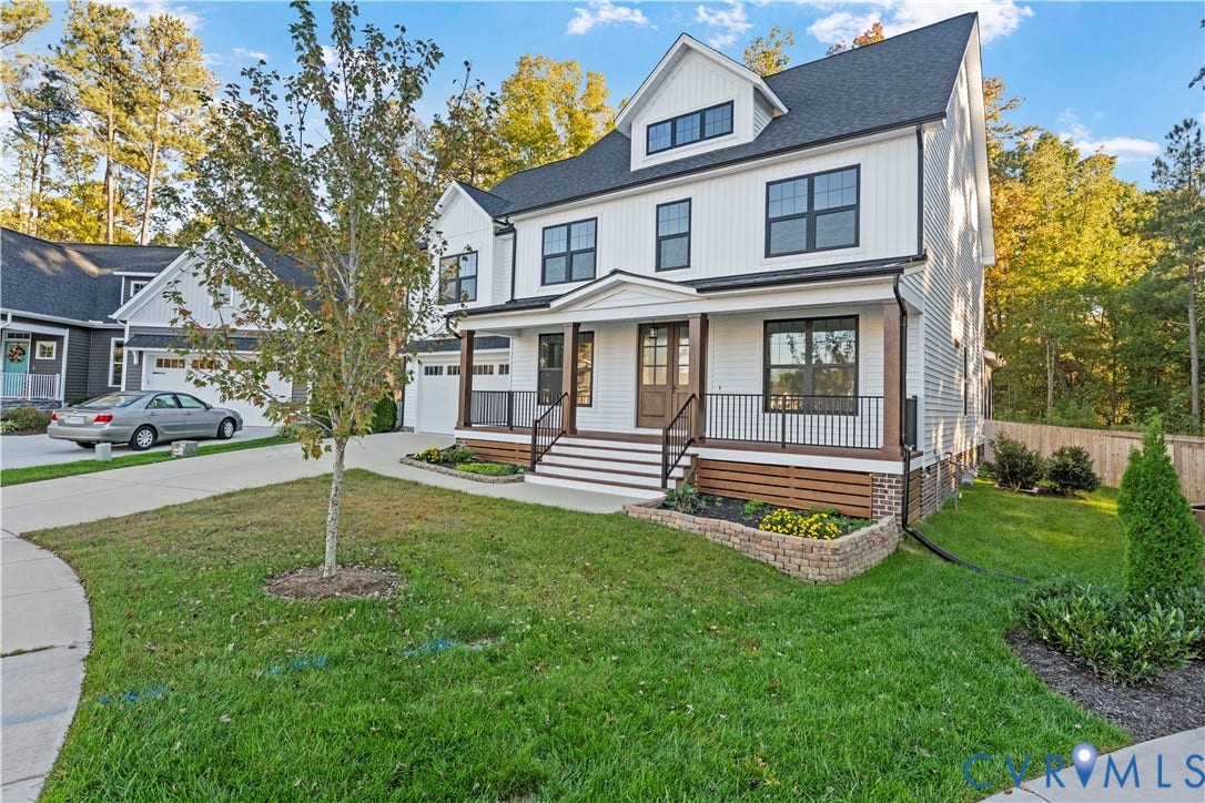 2613 Lilybank Place, NewMarket At RounTrey, Midlothian, VA 23112 Two-story board-and-batten exterior featuring a covered front porch with metal railing, stacked stone garden beds, and multi-pane windows